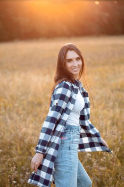 Genç bir kadın gün batımında dışarı çıkıp arkasını dönüyor. İşaret fişeği