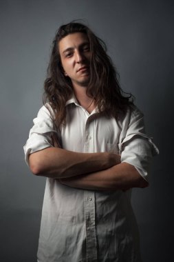 Gri arka planda ciddi bir genç adam. Stüdyo resmi