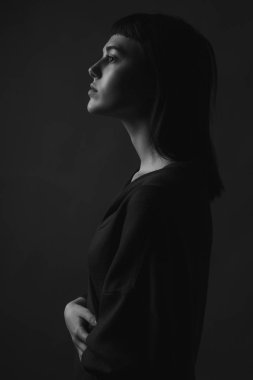 Profilde genç bir kadın. Siyah ve beyaz. Alçak tuş