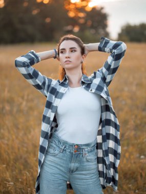 Güzel kız gün batımında dışarıda poz veriyor..