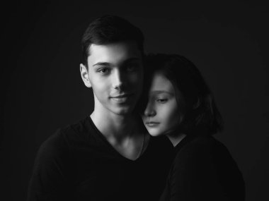 Stüdyoda poz veren genç bir adam ve kız. Siyah ve beyaz