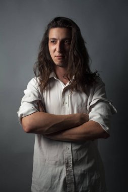 Gri arka planda ciddi bir genç adam. Stüdyo resmi