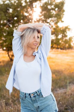 Genç mutlu kadın gün batımında dışarıda yürüyor.