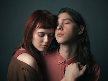 Genç bir kadın ve yakışıklı bir adam stüdyoda sarılıyor..