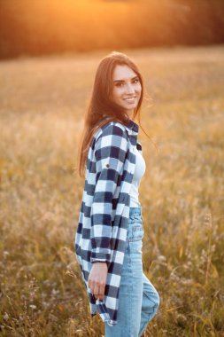 Genç bir kadın gün batımında dışarı çıkıp arkasını dönüyor. İşaret fişeği