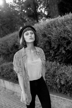 Dışarıda yürüyen genç bir kadın. Siyah ve beyaz.