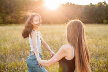Güneşin altında dans eden iki güzel genç kadın, en iyi arkadaşlar.