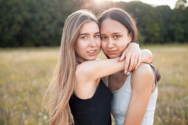 İki güzel genç kadın açık havada sarılmak. En iyi dostlar