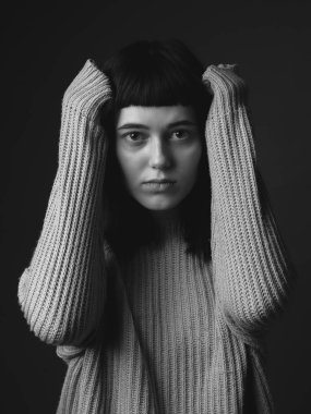 Kafasında elleri olan üzgün genç bir kadının portresi. Siyah ve beyaz