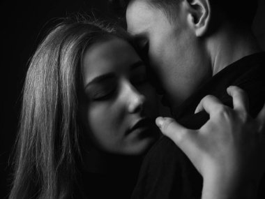 Stüdyoda poz veren genç adam ve kadın. Alçakgönüllülük. Siyah ve beyaz.