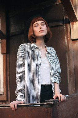 Verandadaki çizgili gömlekli genç mankenin portresi..