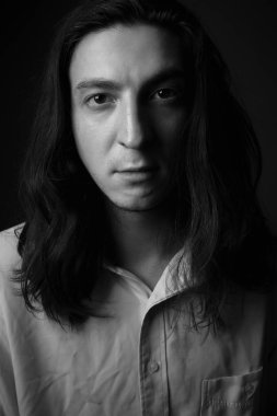 Stüdyoda ciddi bir genç adam var. Siyah ve beyaz. Kapat..