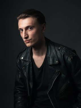 Deri ceketli, ciddi bir adamın portresi..