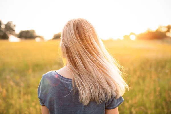 Ung Kvinna Med Blont Hår Står Fältet Och Tittar Solnedgången — Stockfoto
