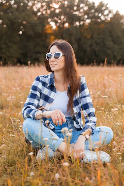 Jonge Vrouw Geruit Shirt Zonnebril Zit Het Droge Gras — Stockfoto