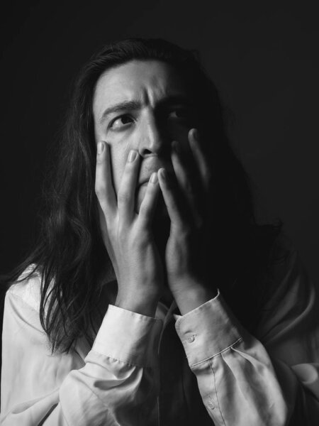 Portrait of young man with long hair. Black and white.