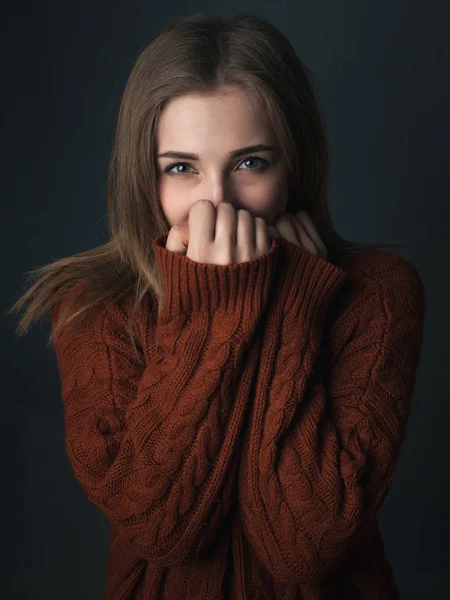 Cute young woman in red sweater. Studio portrait