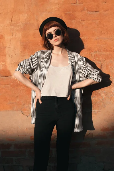 Молодая Женщина Полосатой Рубашке Шляпе Солнцезащитных Очках Позирует Возле Оранжевой — стоковое фото