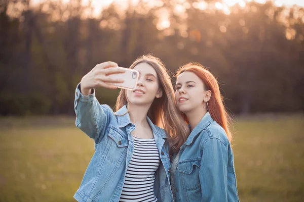 Two young women shooting selfie outdoors. Best friends