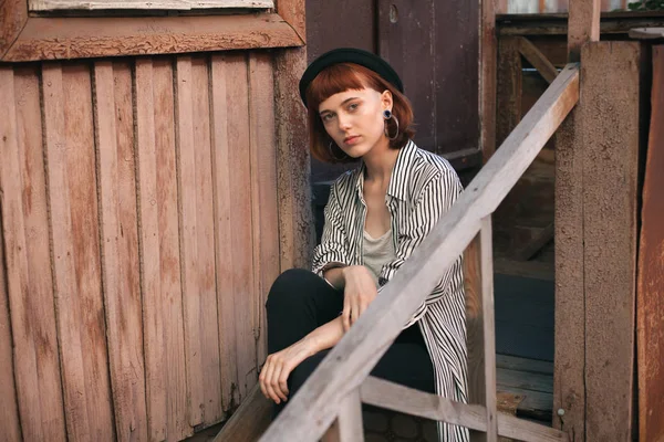 Fashionable young woman sitting on the porch.