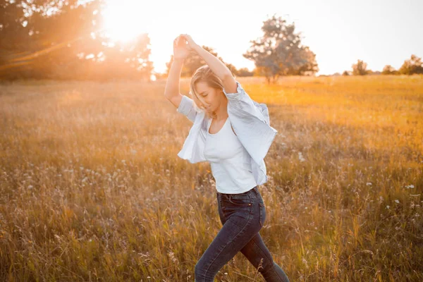 Gün batımında dışarıda yürüyen genç bir kadın. İşaret fişeği