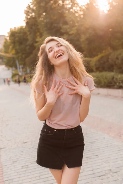 Young woman laughing in the city under the sunlight