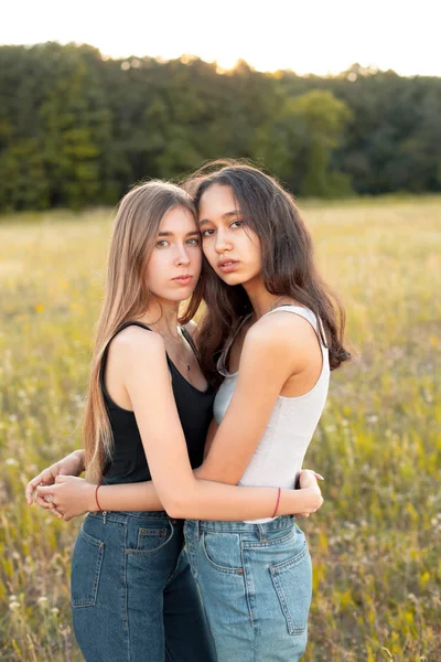 Δύο Όμορφες Νεαρές Γυναίκες Αγκαλιάζονται Στην Ύπαιθρο Κάτω Από Φως — Φωτογραφία Αρχείου