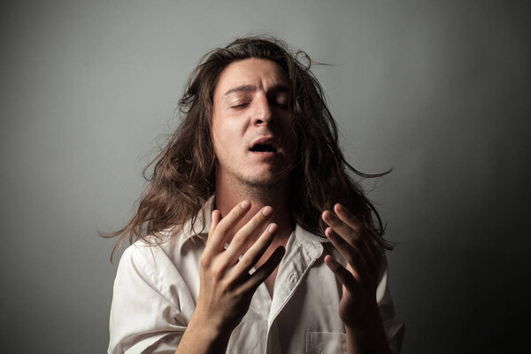 Depression. Portrait of young man on gray background.