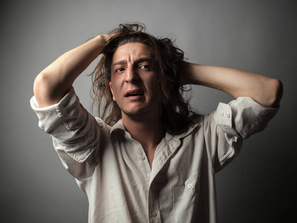 Despair. Portrait of young man on gray background