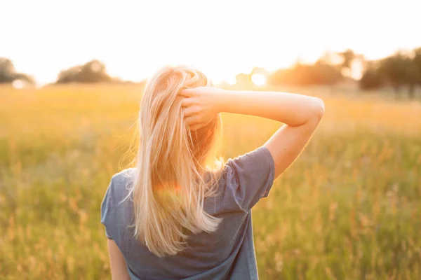 Ung Kvinna Med Blont Hår Står Fältet Och Tittar Solnedgången — Stockfoto