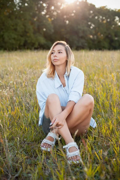Attraktiv Ung Kvinna Blå Skjorta Sitter Gräset Solljus — Stockfoto