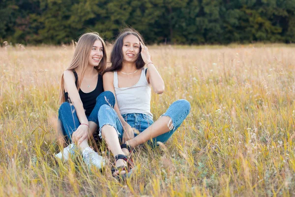 Δύο Όμορφες Νεαρές Γυναίκες Κάθονται Στο Γρασίδι Και Διασκεδάζουν Καλύτεροι — Φωτογραφία Αρχείου