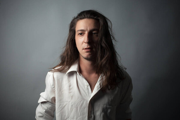 Worried young man on gray background. Studio portrait