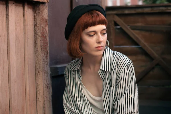 Fashionable young woman sitting on the porch.