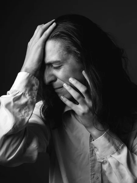 Depressed young man with long hair. Black and white