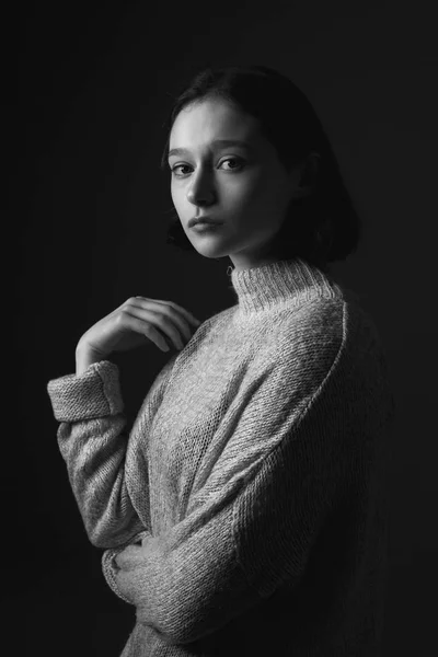 Portrait of beautiful woman in dark studio. Black and white.