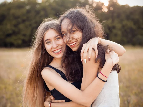 两个快乐的女孩在阳光下拥抱在外面 好朋友 — 图库照片