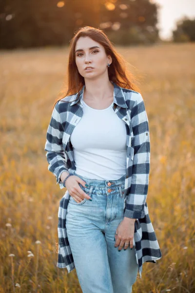 Çekici kız gün batımında sahada yürüyor..