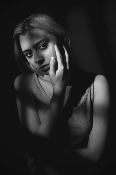Portrait of a young woman in shadows. Black and white