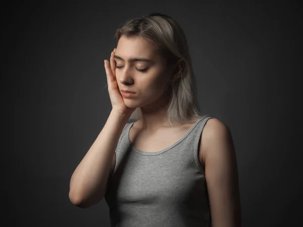 Portrait of sad girl on gray background. Studio