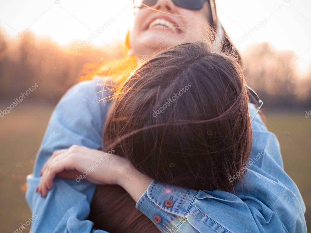 Two young women having fun and hugging outdoors. Close up. Best friends