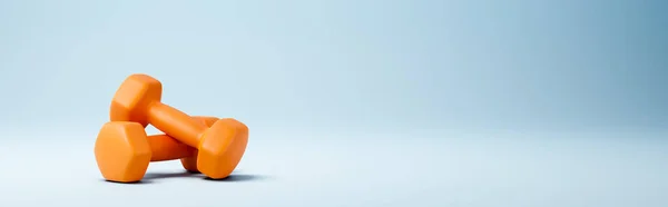 블루 백 그라운드의 오렌지 덤벨 — 스톡 사진