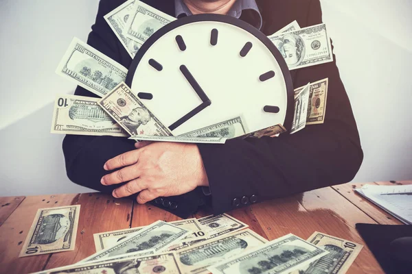 Επιχειρηματίες Κάθονται Στο Τραπέζι Εργασίας Και Κρατώντας Ρολόι Και Χρήμα — Φωτογραφία Αρχείου
