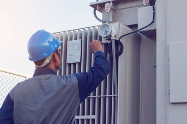 mühendis veya yeşil enerji güneş enerjisi santrali, kontrol ve bakım donanımları üzerinde çalışan elektrikçi; durumu adım kadar trafo yüksek gerilim trafo yar, kontrol