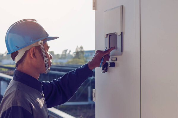 engineer or electrician working on checking and maintenance equipment at green energy solar power plant: checking status inverter