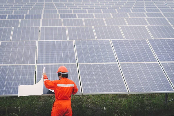 Inżynier w elektrowni słonecznej pracujący nad instalacją paneli słonecznych — Zdjęcie stockowe