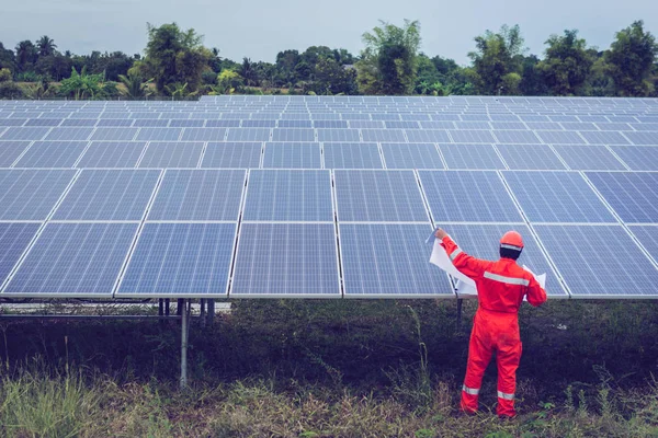 Inżynier w elektrowni słonecznej pracujący nad instalacją paneli słonecznych — Zdjęcie stockowe