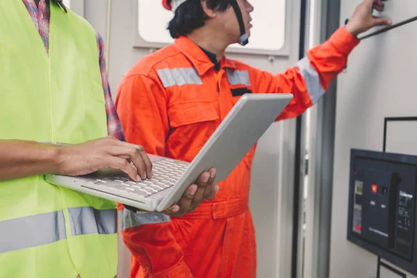 Ingeniero o electricista que sostiene el ordenador portátil para inspeccionar y comprobar — Foto de Stock