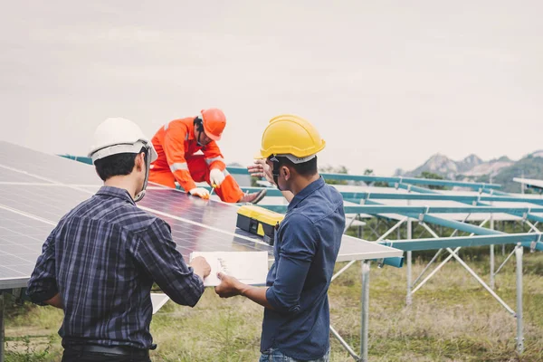 Inżynier w elektrowni słonecznej pracujący nad instalacją paneli słonecznych — Zdjęcie stockowe