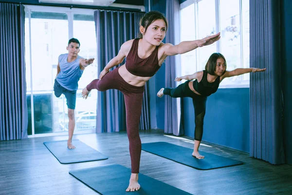 Yoga group concept; young people practicing yoga in class; feeli